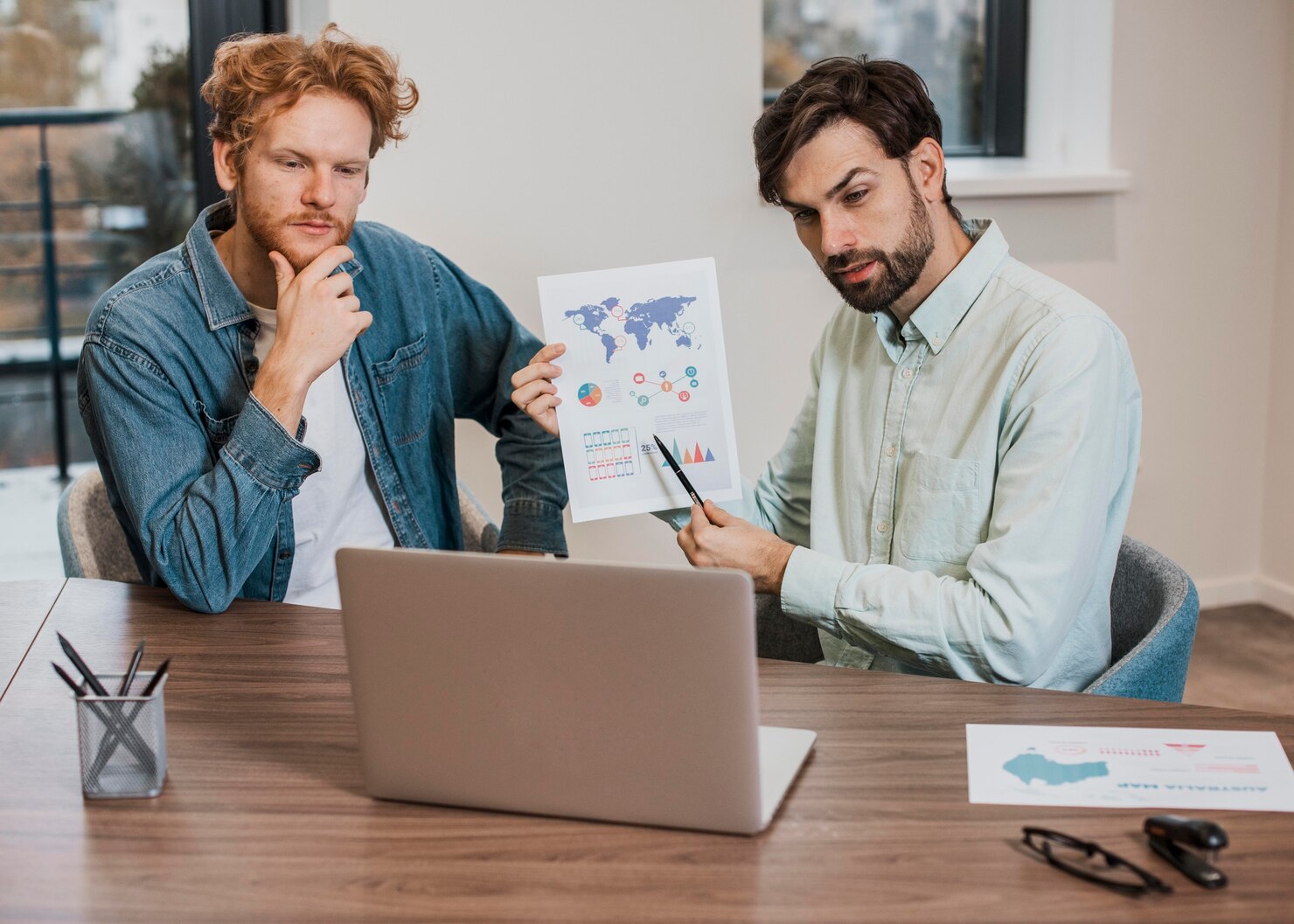 Two men review charts and graphs, discussing SEO cost in Wisconsin.