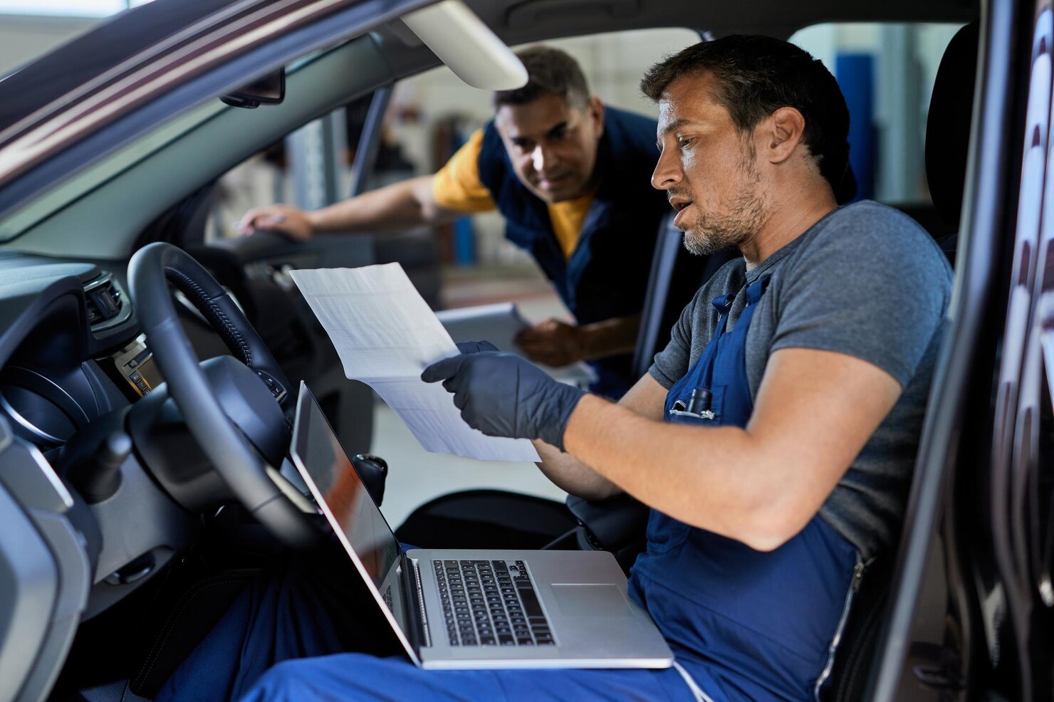 Mechanics review vehicle diagnostics in a Wisconsin auto shop.